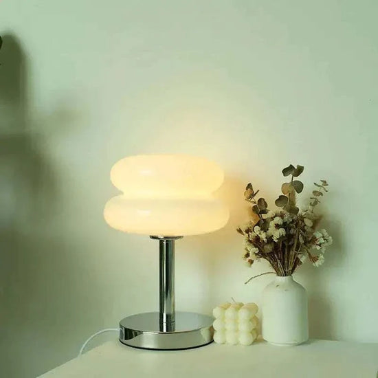 Macaron LED Lamp with milky white macaron-shaped diffuser and sleek chrome stand emitting warm light