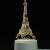 3D LED Lamp shaped like the Eiffel Tower in yellow light with delicate lattice design on a white base