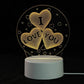 3D LED Lamp with a white base and a yellow glowing 3D optical illusion design of three heart shapes with the words I LOVE YOU