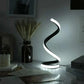 Modern LED Spiral Table Lamp with three-speed dimming and USB-powered button switch on a bedside table