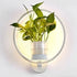 Modern wall plant LED lamp with green foliage and soft illumination on white wall