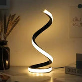 LED Spiral Table Lamp with three-speed dimming and USB-powered button switch on a bedside table