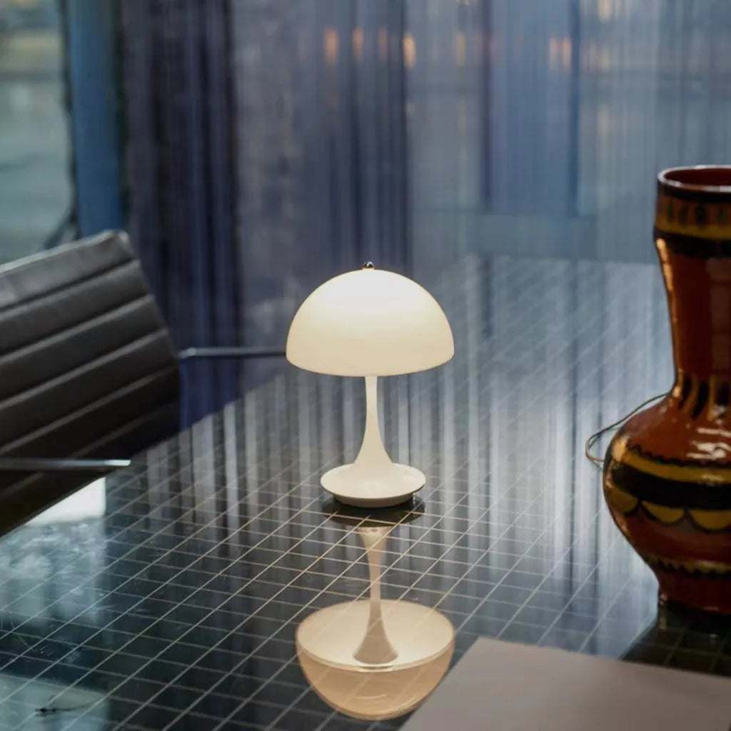 Portable rechargeable LED lamp with touch dimming and USB charging on a wooden surface