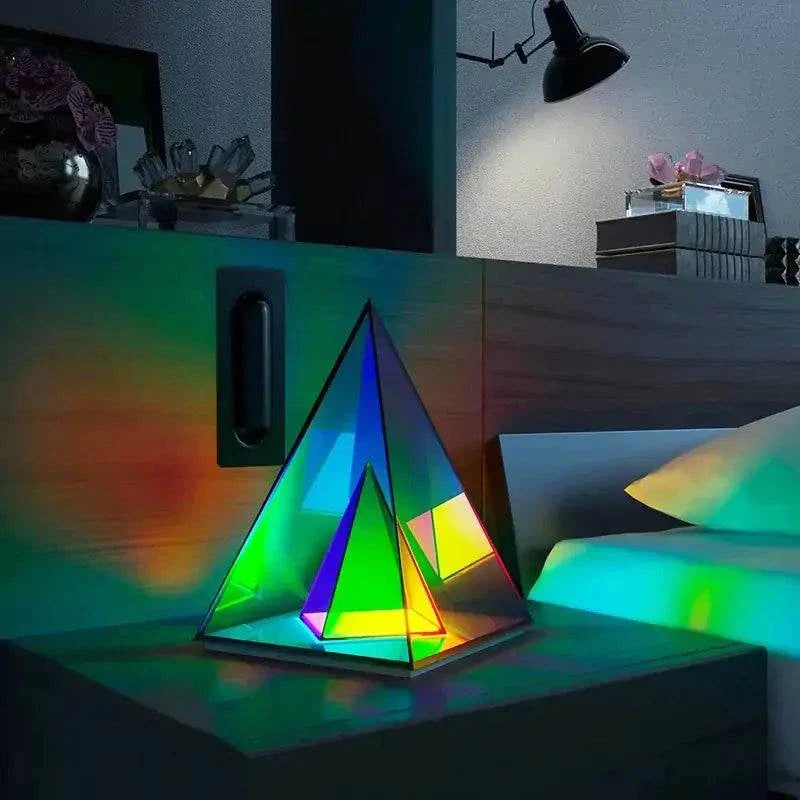 Aura Pyramid Lamp with multicolored translucent acrylic panels creating a vibrant ambient glow on a bedside table