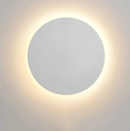 Circular Wall Light with a sleek white circular metal and acrylic design and warm white backlight glow on the wall.