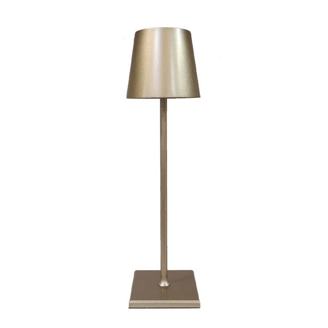 Cordless lamp with a metallic gold finish, sleek design, and minimalist shade on a slim stand and square base.