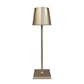 Cordless lamp with a metallic gold finish, sleek design, and minimalist shade on a slim stand and square base.