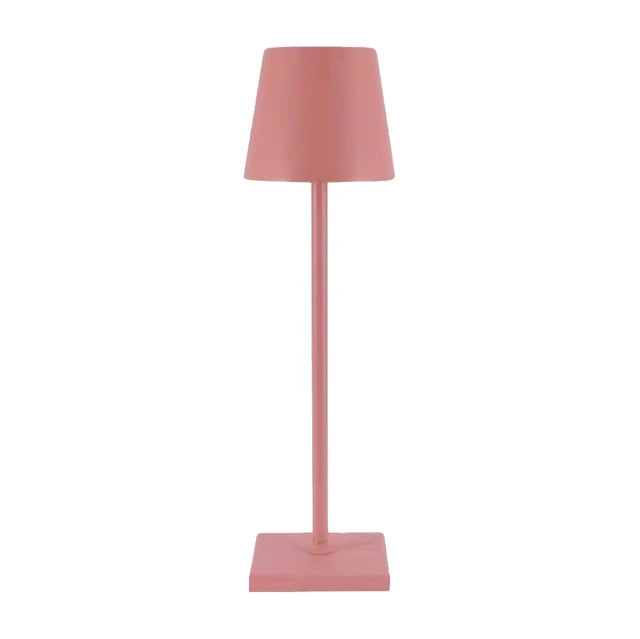 Cordless lamp in muted pink color with a minimalist design, featuring a conical shade and square base.