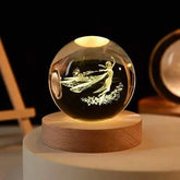 Crystal Night Ball, clear glass sphere with etched fairy design on a natural wood base, softly illuminated