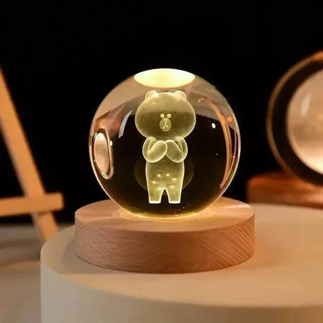 Crystal Night Ball featuring a clear glass globe with bear figurine and warm light on a round wooden base