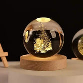 Crystal Night Ball, clear glass sphere with engraved Christmas tree and Santa design on a natural wood base