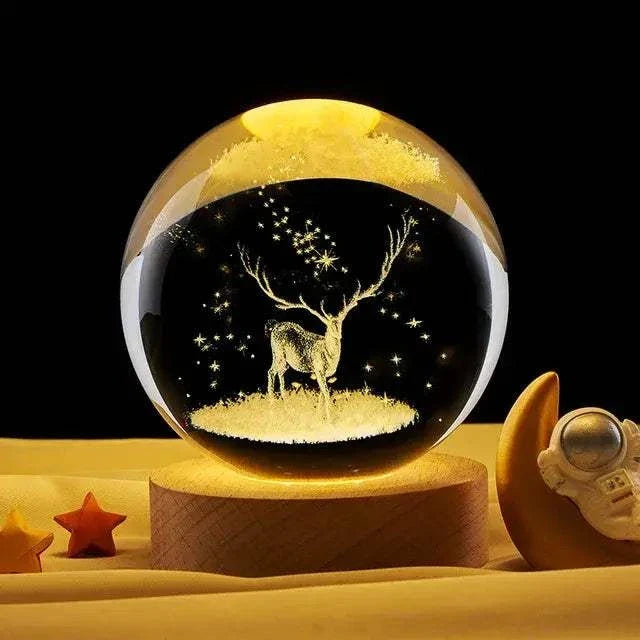 Crystal Night Ball, amber glass globe with etched glowing deer and stars on a wooden base