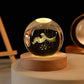 Crystal Night Ball, transparent glass sphere with engraved astronaut and star details on a round wooden base