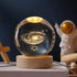 Crystal Night Ball, transparent glass sphere with glowing galaxy pattern on a natural wood base
