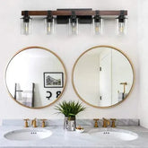Farmhouse Dresser Lamps featuring a rustic black iron frame with clear glass shades mounted above dual round mirrors in a bathroom setting