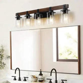 Farmhouse Dresser Lamps with rustic black iron frame and walnut-colored glass shades mounted above bathroom mirror