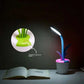 Flower Lamp with flexible blue stem, white flowerpot base, pink rim, and soft LED light illuminating an open book