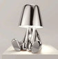 Impression LED Lamp with shiny chrome finish featuring a playful seated figure base and a smooth reflective lampshade