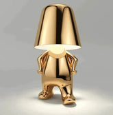 Impression LED Lamp with a shiny gold metallic finish and a unique anthropomorphic design featuring a figure holding the lampshade