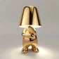 Impression LED Lamp in shiny gold metallic finish with a playful humanoid figure base holding up a smooth lampshade