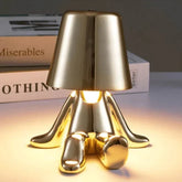Impression LED Lamp with a gold metallic finish and a modern, abstract base design featuring smooth, curved shapes emitting warm light