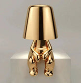 Impression LED Lamp with a shiny gold finish featuring a unique human figure base design and smooth lampshade