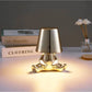 Impression LED Lamp in metallic gold with a unique human figure base and smooth lampshade providing warm, soft light