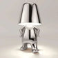 Impression LED Lamp in shiny metallic silver finish, designed as a small humanoid figure with a reflective lampshade head and glowing light beneath it