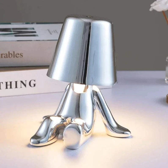 Impression LED Lamp in shiny silver metal with a modern, abstract human-figure design and smooth reflective finish