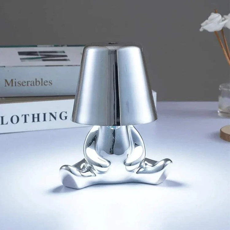 Impression LED Lamp with a shiny silver metallic finish featuring a modern playful figure shape and compact size