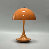 Portable rechargeable LED lamp with metal lampshade and USB charging on wooden table