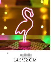 LED Neon Light shaped like a flamingo in bright pink on a round clear base, glowing vividly and decorative