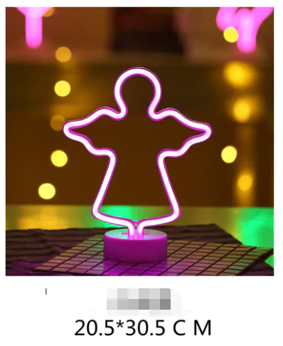 LED Neon Light shaped like an angel in glowing pink mounted on a white circular base with a grid pattern underneath