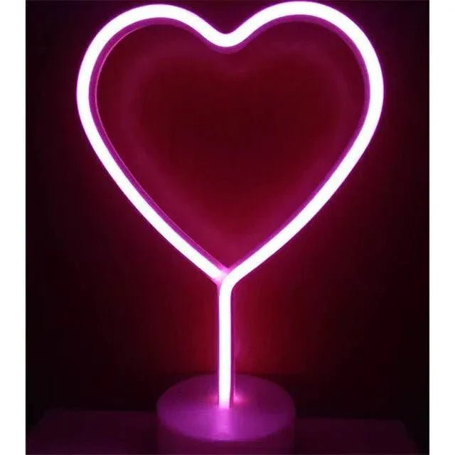 LED Neon Light in bright pink PVC shaped like a heart with a clear round base, glowing vibrantly in the dark