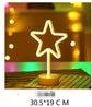 LED Neon Light in the shape of a star glowing warm white on a clear round base with a modern design