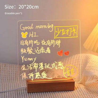 LED Note Board with clear acrylic surface and warm yellow illuminated handwritten messages, resting on a wooden base
