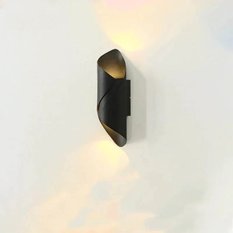 LED Waterproof Outdoor Wall Lamp in black metal with a twisted cylindrical shape and warm light glowing from top and bottom