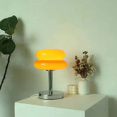 Macaron LED Lamp with two stacked orange rounded shades, a chrome stem and circular metal base