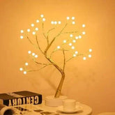 Mini Christmas Tree LED lamp with gold wire branches and warm white glowing LED lights on a white round base