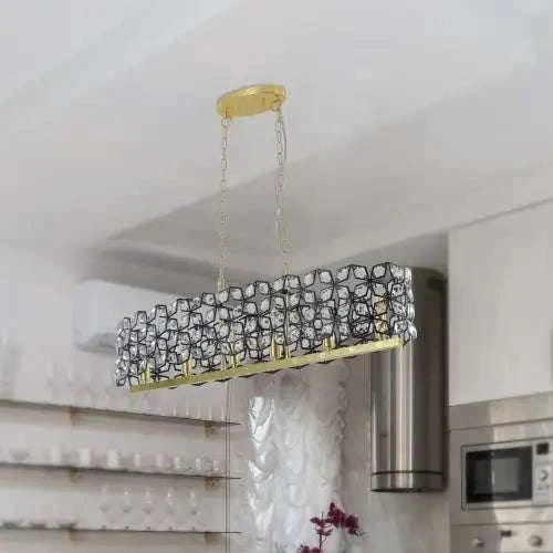 Modern Champagne Gold oval chandelier with black metal frame and clear crystal grid pattern suspended by gold chains in kitchen interior