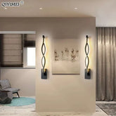 Modern Wall Lamps featuring sleek black aluminum bodies with twisted design and warm up-down LED illumination, mounted on a beige wall.