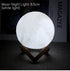 Moon Lamp with white LED light and detailed lunar surface texture on a natural wooden V-shaped stand glowing softly