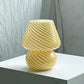 Mushroom LED Lamp in yellowish amber glass with a spiral stripe pattern and a bubble streamline design