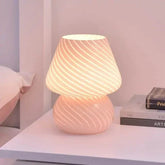 Mushroom LED Lamp in translucent pink glass with spiral white stripes and compact rounded shape emitting warm light