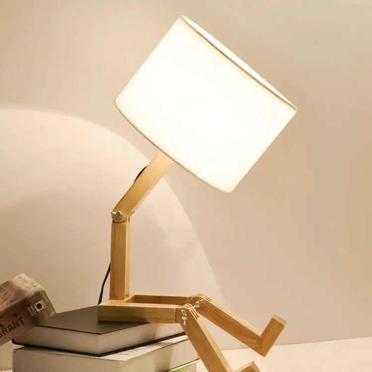 Robot Table Lamp with white fabric shade and wooden adjustable articulated arm resembling a robot figure sitting pose