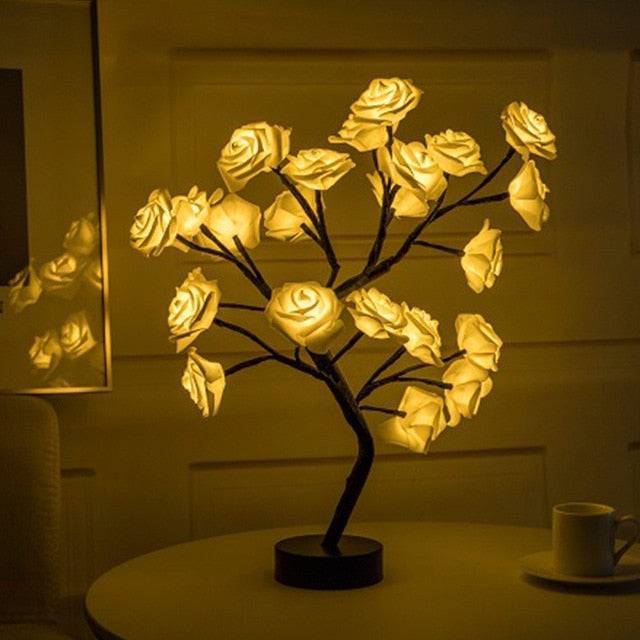 Rose Tree Lamp with warm yellow LED lighting shaped as glowing rose petals on a black metal stem and round base
