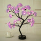 Rose Tree Lamp featuring pink synthetic flower petals with warm LED lighting on a black metal stem and round base