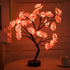 Rose Tree Lamp with warm glowing pink synthetic rose petals on dark metal branches and round black base