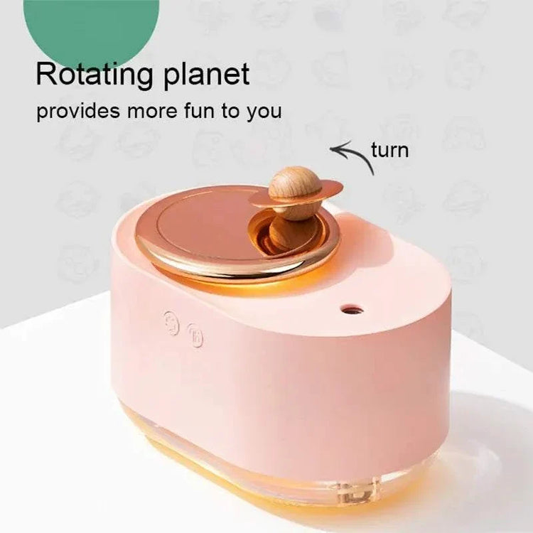 Rotating Planet Aroma Diffuser in soft pink with a golden rotating planet feature and wooden ring detail on top