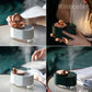 Rotating Planet Aroma Diffuser in white and green with copper top and planet-shaped knob, emitting fine mist in various usage settings